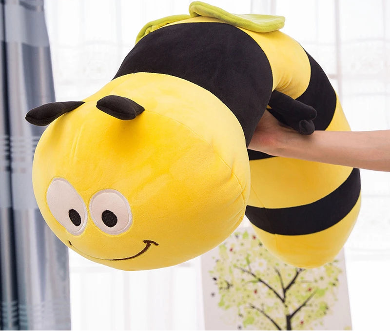 Peluche de abeja colgando sobre el brazo de una persona, forma flexible y alargada